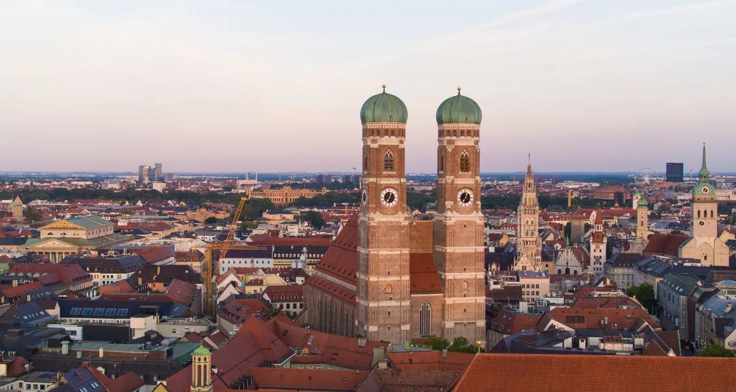 Blick über die Dächer der Münchner Altstadt auf die Frauenkirche im Abendlicht